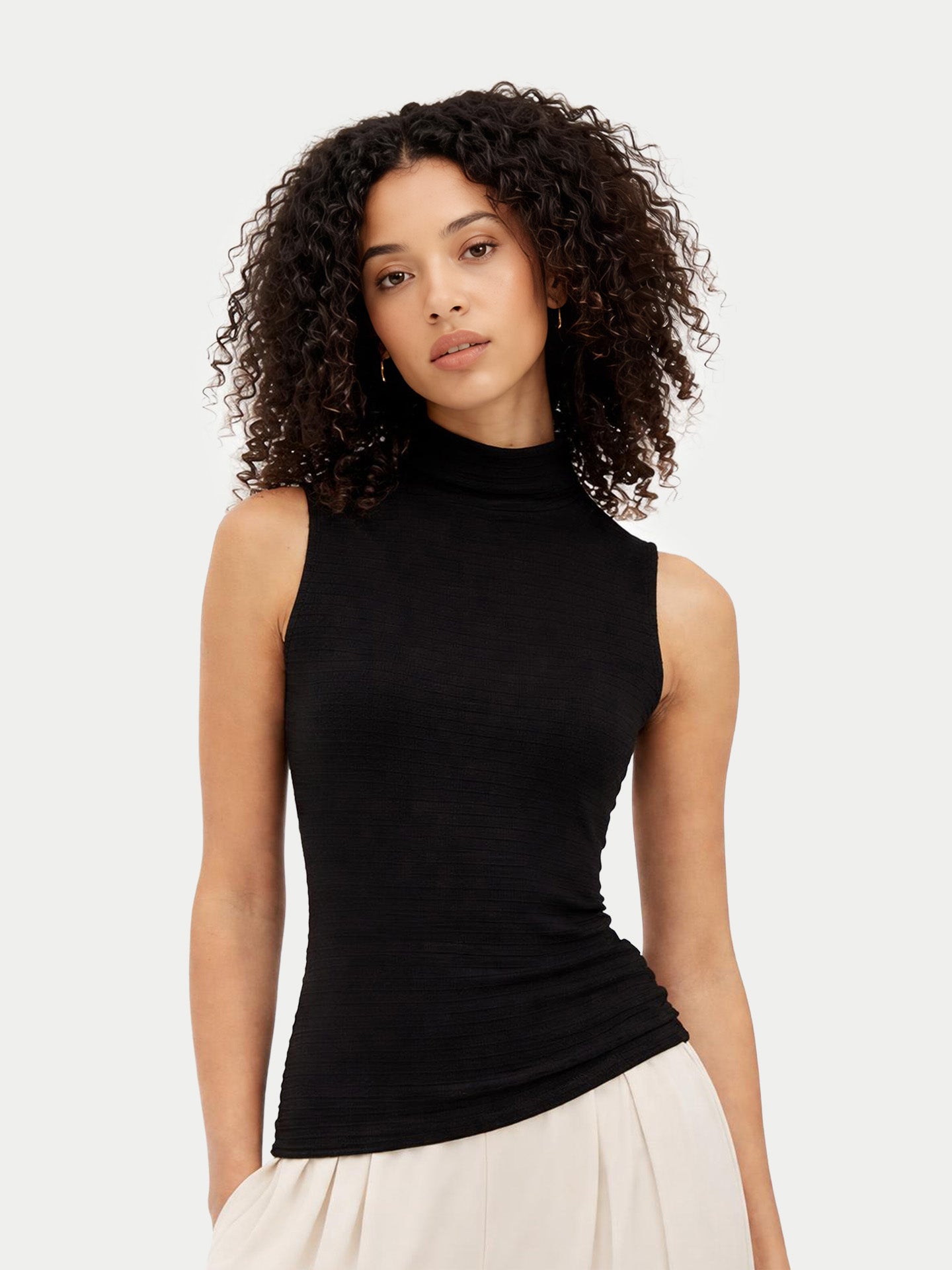 Woman wearing a black sleeveless top against a white background